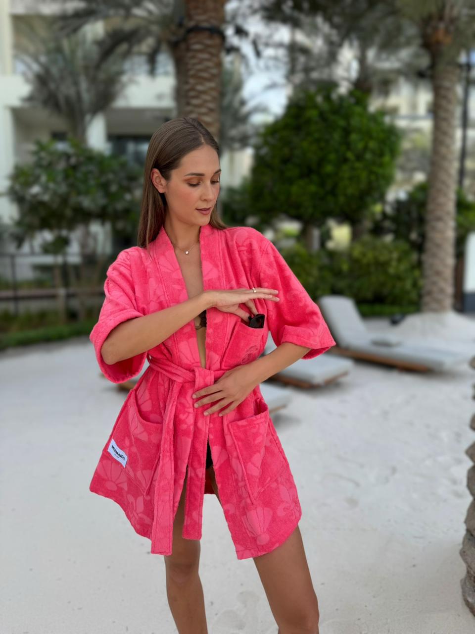 Woman in red beach robe Five Palm Dubai sunset pulling sunglass — Mermaids Club